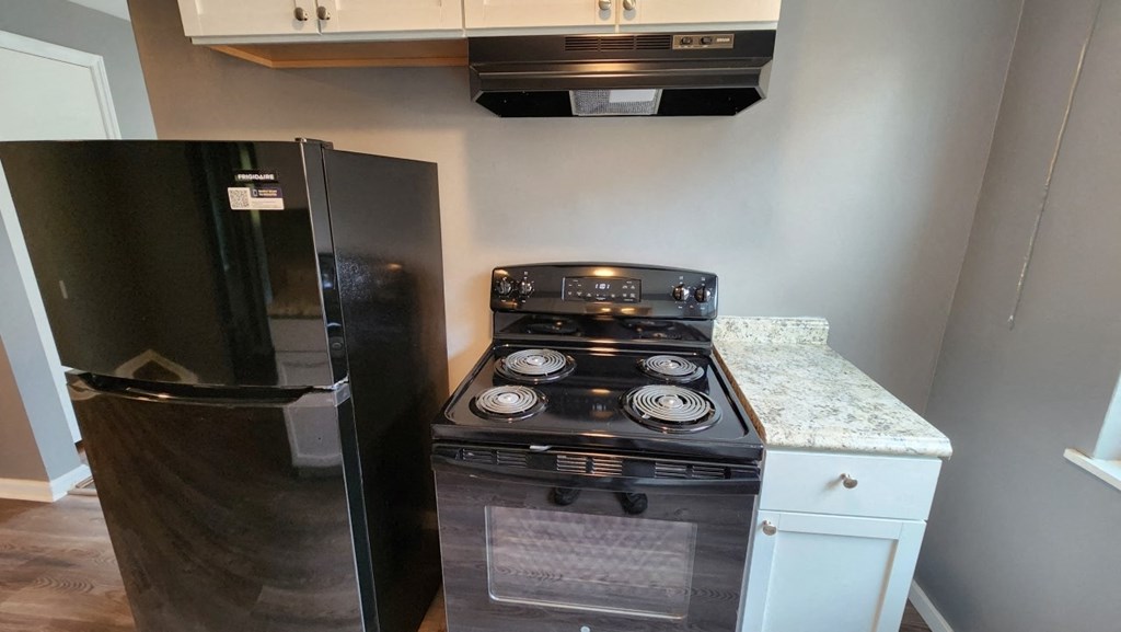 a small kitchen with a stove and a refrigerator