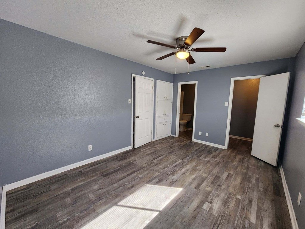 a living room with wood floors and a ceiling fan
