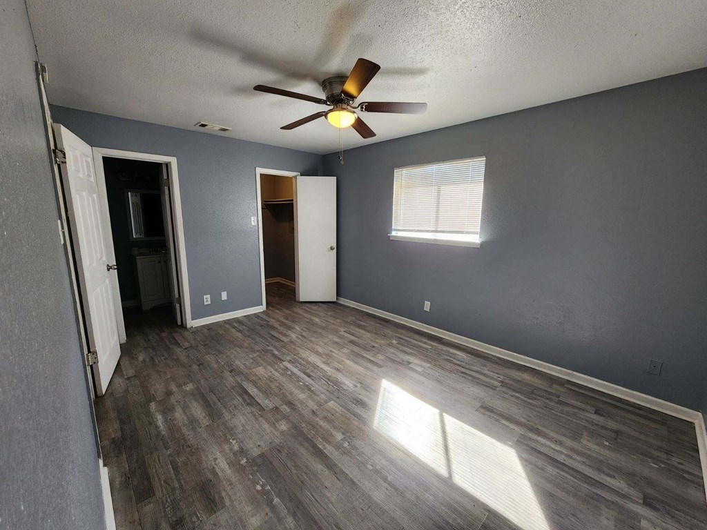 a living room with gray walls and a ceiling fan