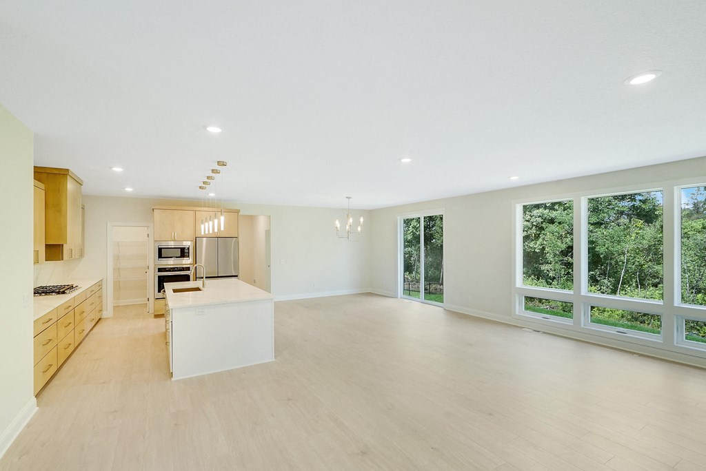 a large living room with a kitchen and a large window