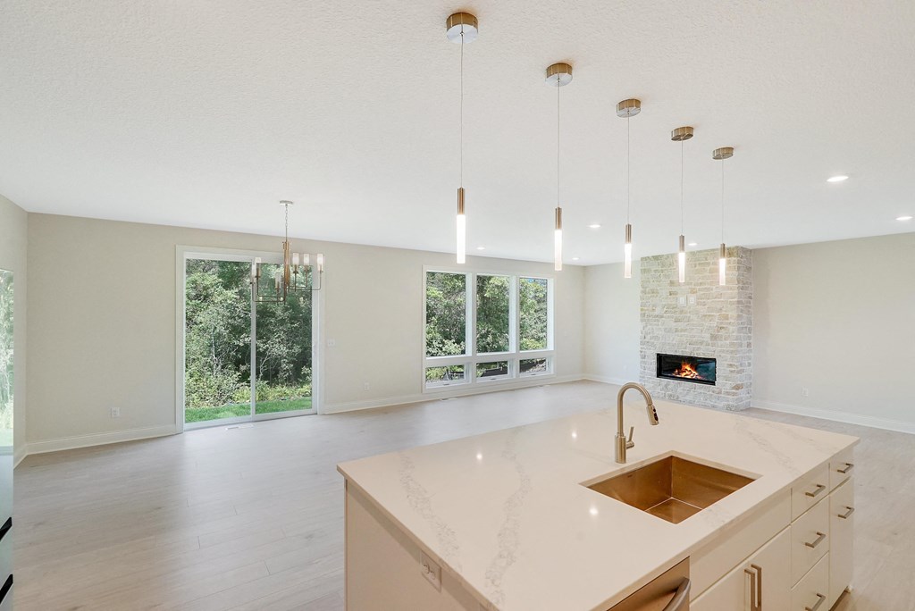 an open kitchen and living room with a sink and a fireplace