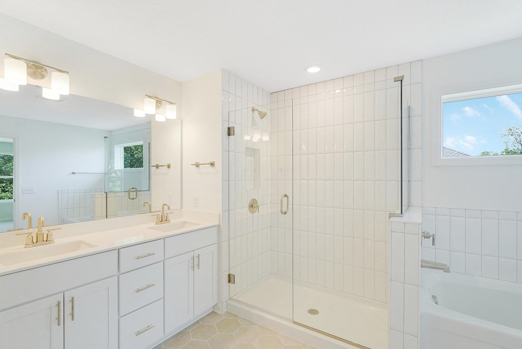 a white bathroom with a shower and two sinks