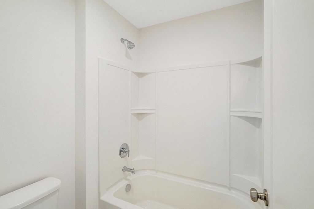 a white bathroom with a shower and a tub