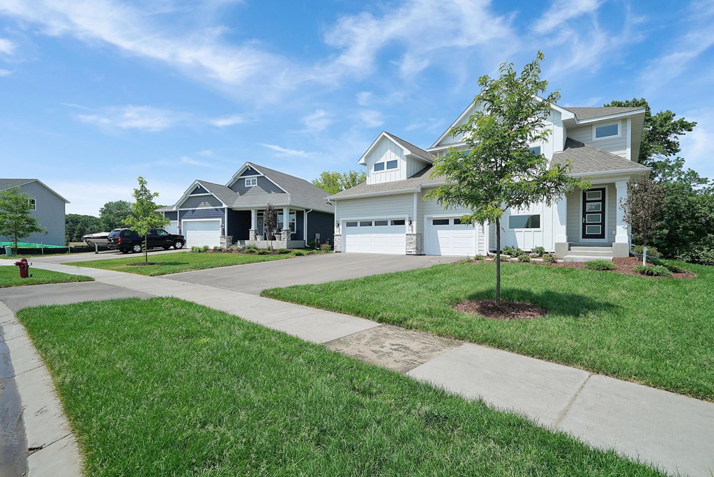a house with a lawn and a sidewalk in front of it