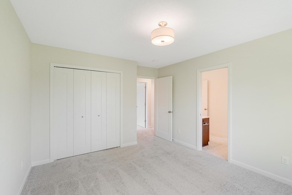 a bedroom with a closet and a door to a hallway