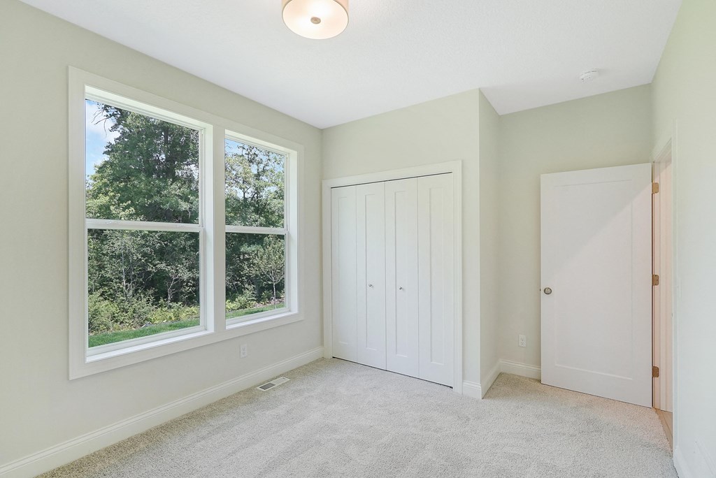 a bedroom with a large window and a white door