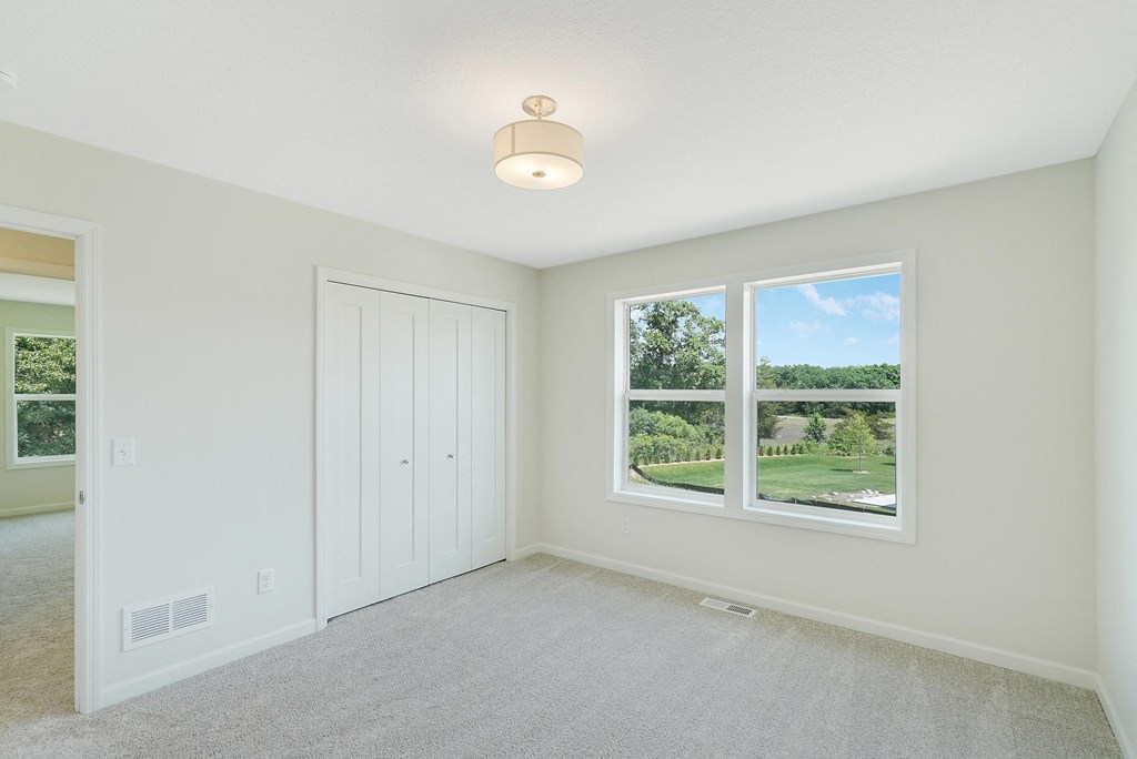 a bedroom with a large window and a closet