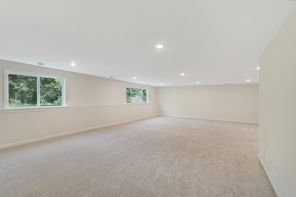 a spacious living room with carpet and a window