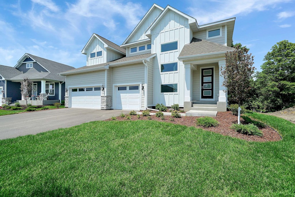a white house with a driveway and a lawn