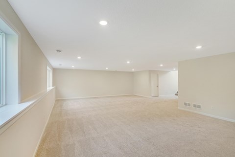 a spacious living room with white walls and a white carpet