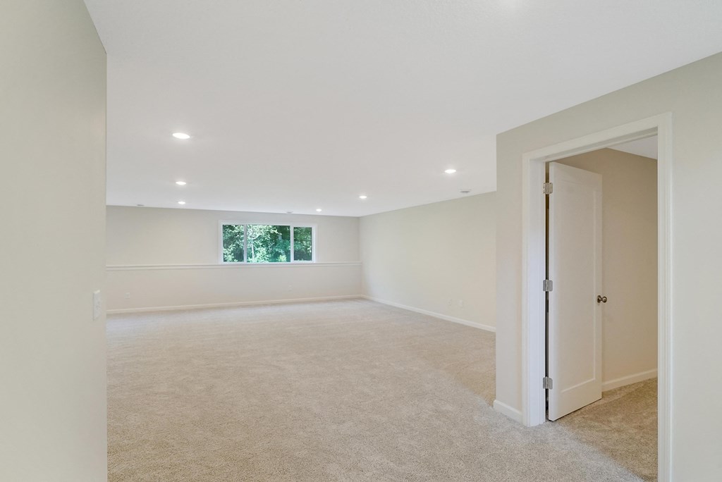 an empty living room with a door to a bedroom