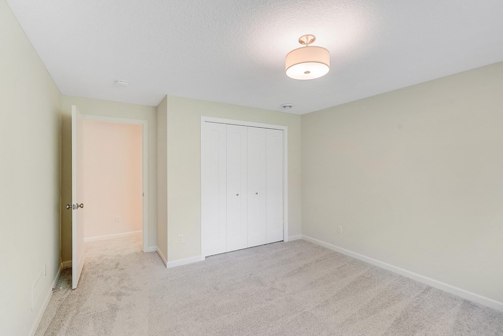 an empty bedroom with a closet and a door to the bathroom