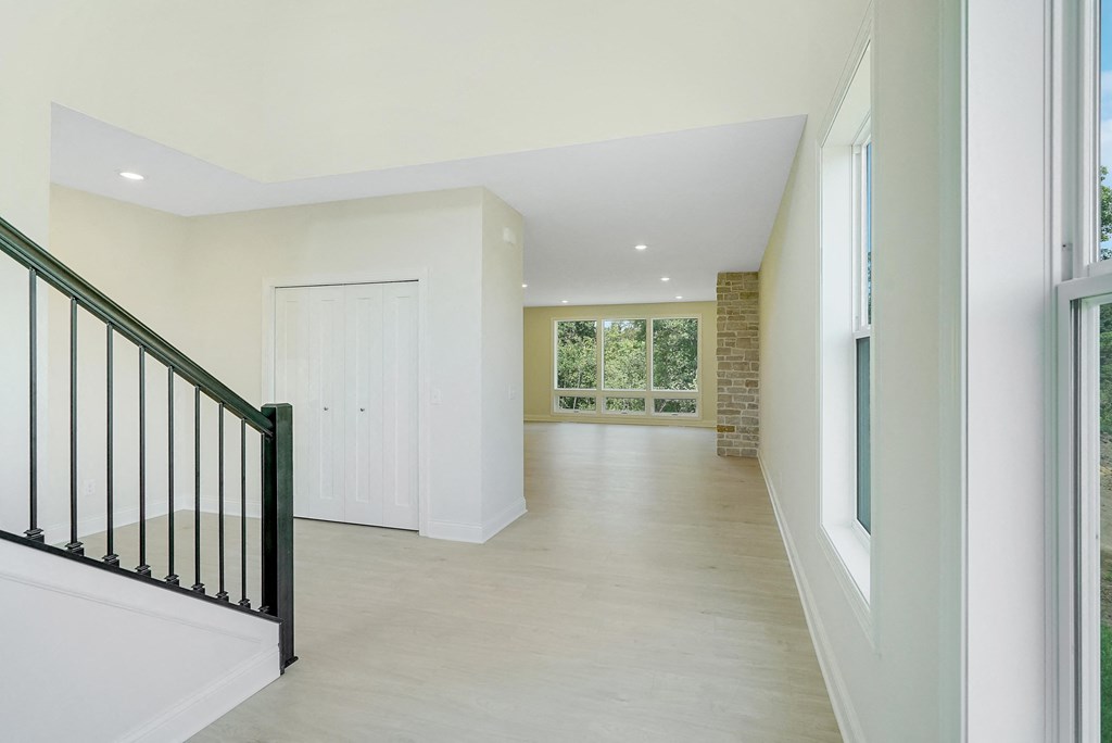 the view from the top of the stairs looking into the living room and dining room