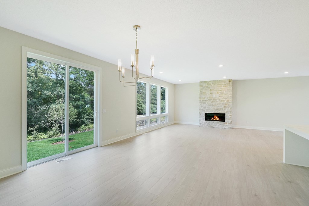 an empty living room with a fireplace and a large window