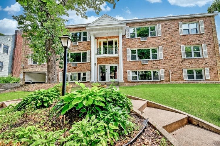 a large brick building with a garden in front of it