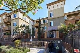 an apartment building with a sidewalk and a gate