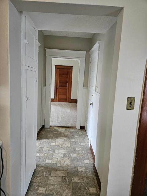 a bedroom with a bed and a hallway with a door open