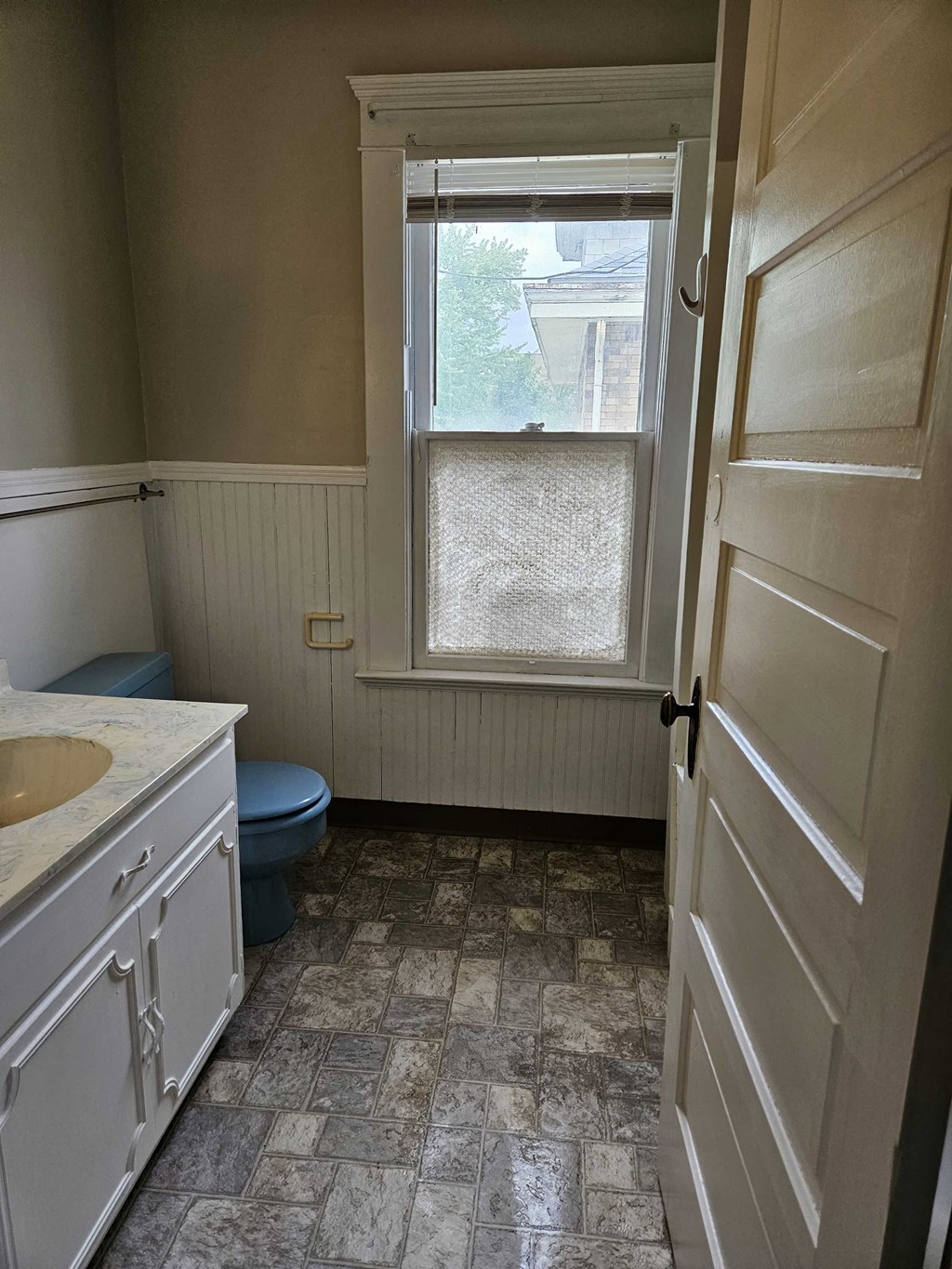 a bathroom with a window and a sink and a toilet