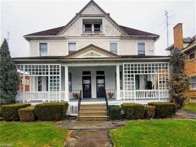 a white house with a porch and a lawn