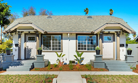 A house with a grey roof and white walls with a small front porch.