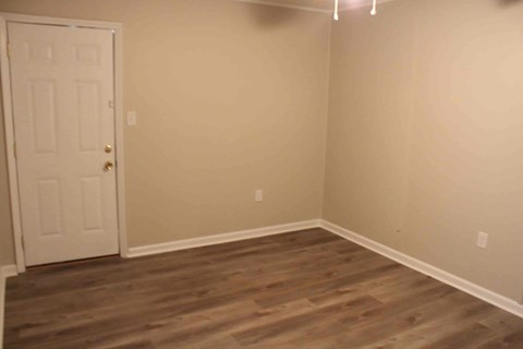 an empty room with wooden floors and a white door