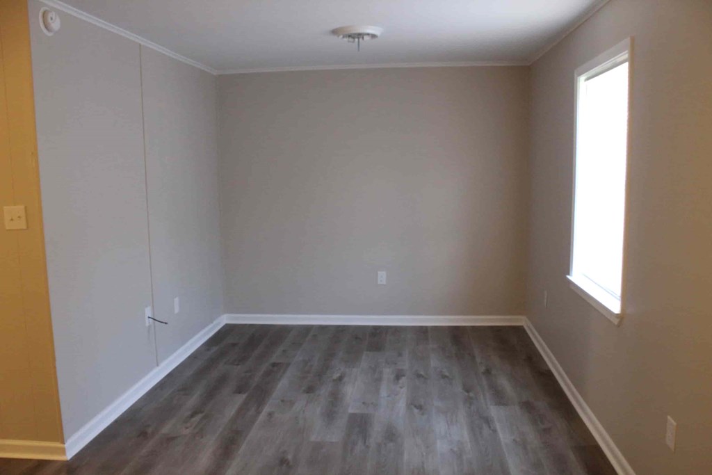 a empty room with wooden floors and a white wall