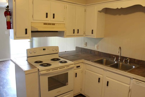 a kitchen with white cabinets and a stove and sink
