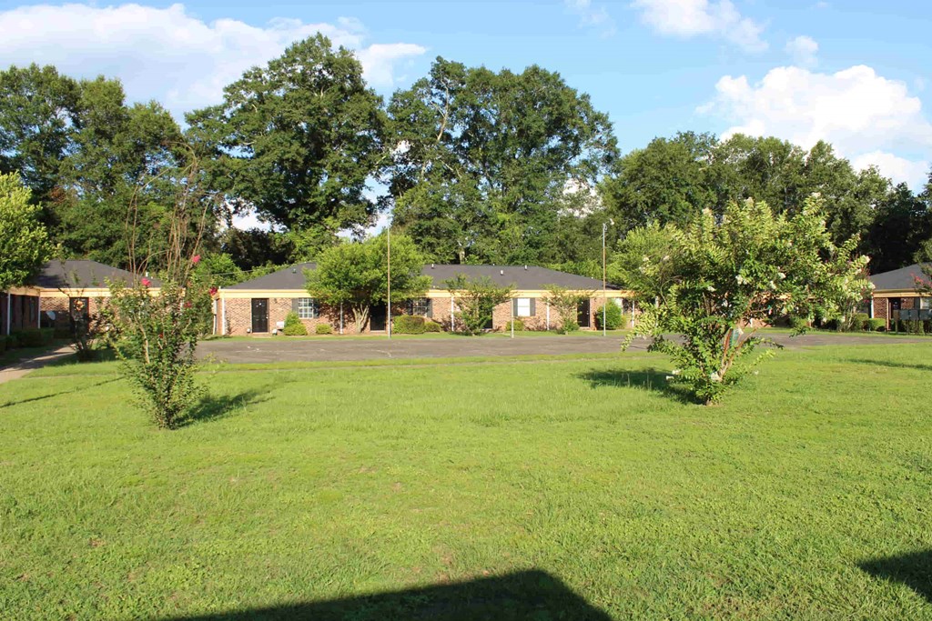 a large yard in front of a house with trees