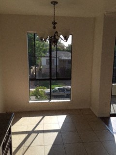 a living room with a window and a chandelier
