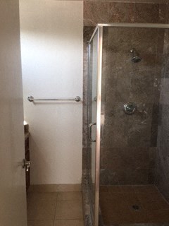 a bathroom with a shower and a towel rack in it