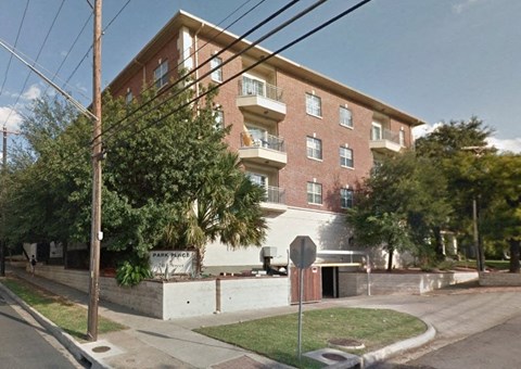 a brick apartment building on the corner of a street