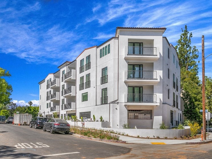 a white apartment building with cars parked in front of it