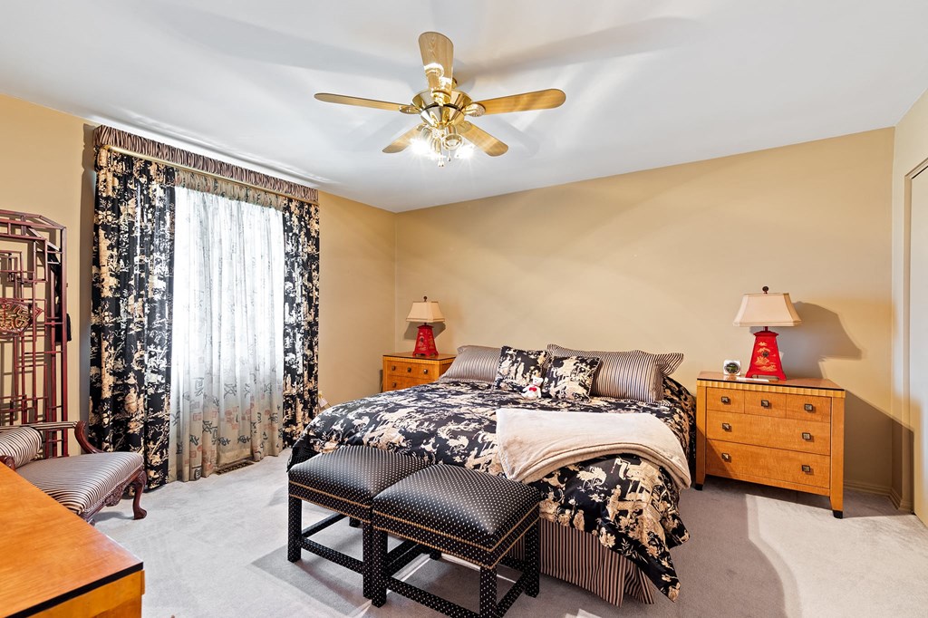 a bedroom with a bed and a ceiling fan