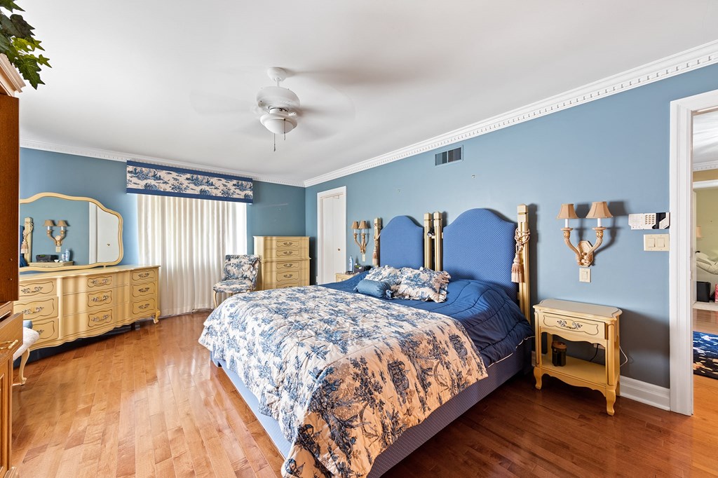 a bedroom with a bed and a dresser and a ceiling fan