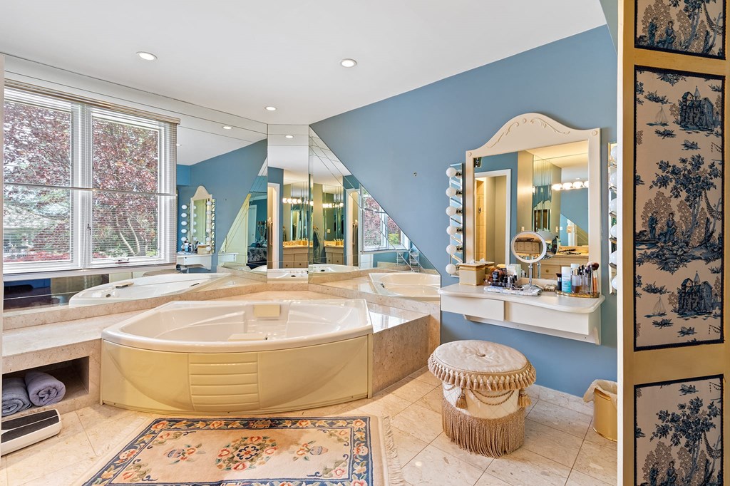 a bathroom with a tub and a sink and a mirror
