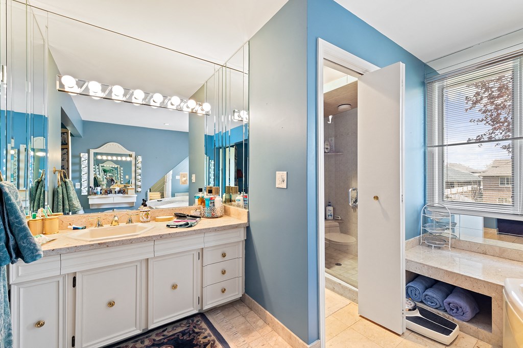 a bathroom with a sink and a shower and a mirror