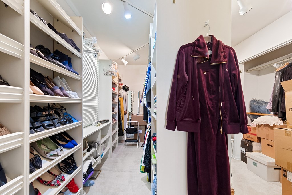 a walk in closet with shelves and racks of shoes and clothes