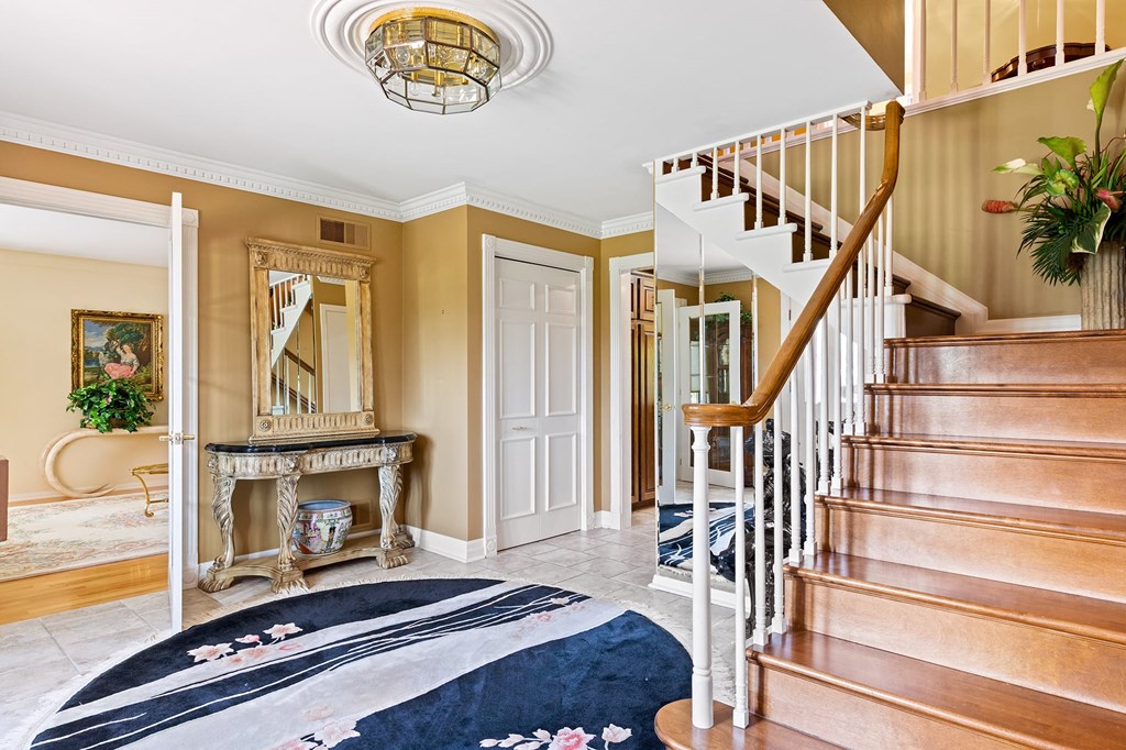 the entryway of a house with stairs and a blue rug