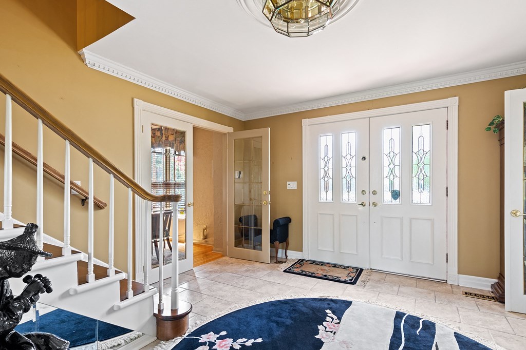 the entryway of a house with a staircase and a blue rug on the floor