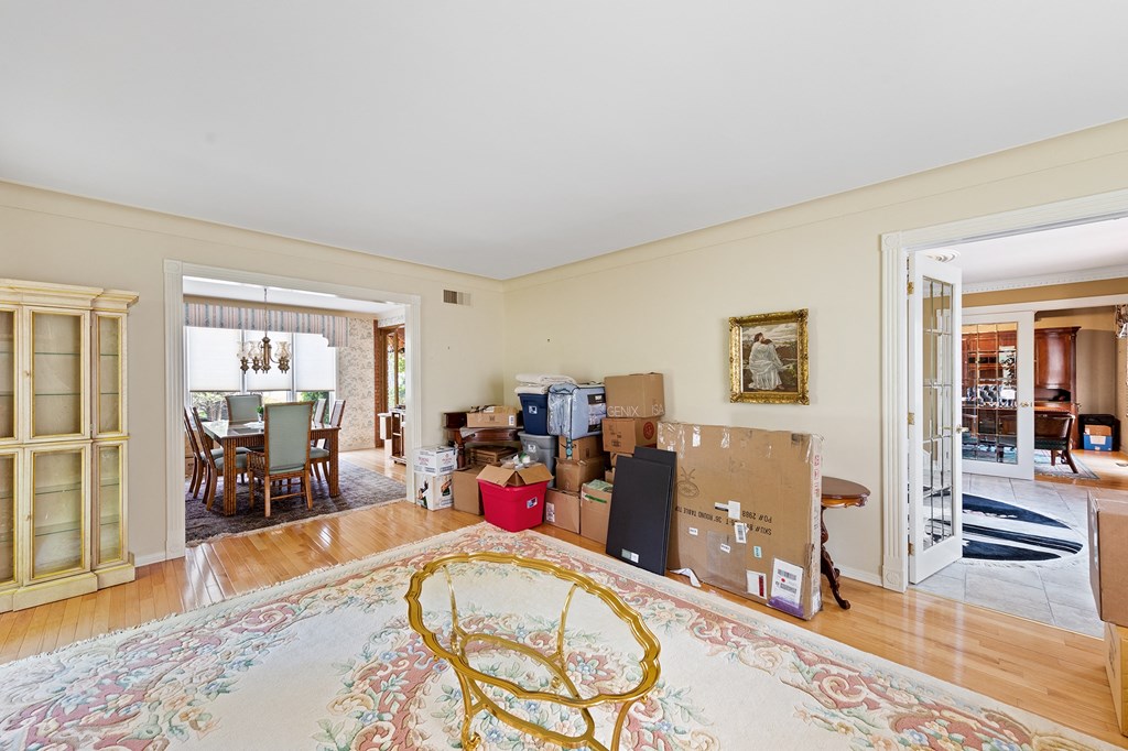 the living room and dining room are filled with boxes and a rug
