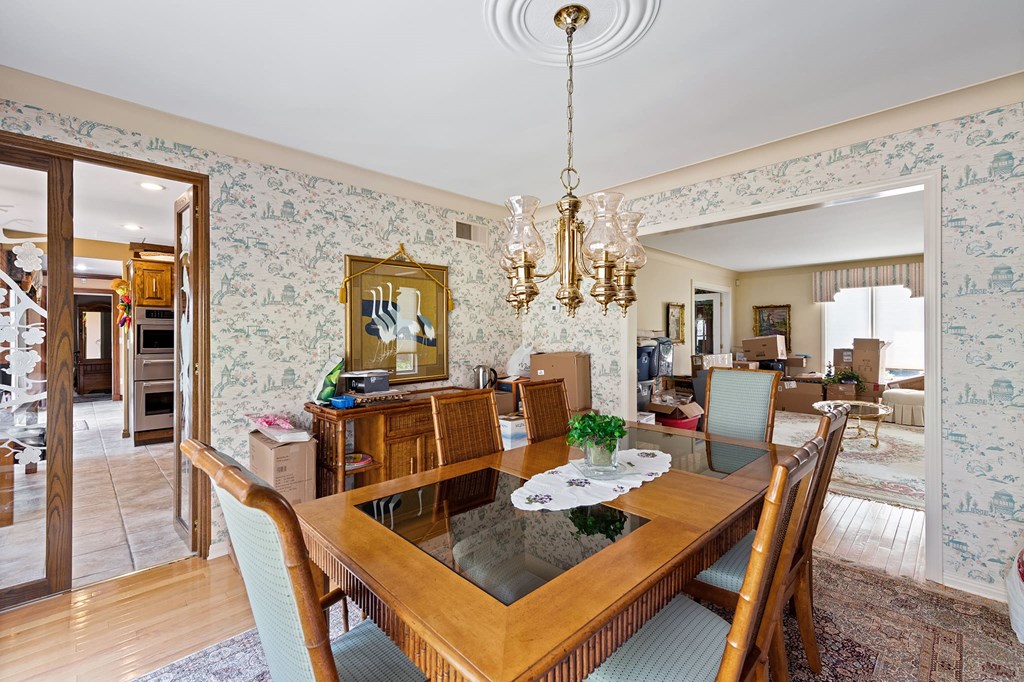 a dining room with a wooden table and chairs and a chandelier