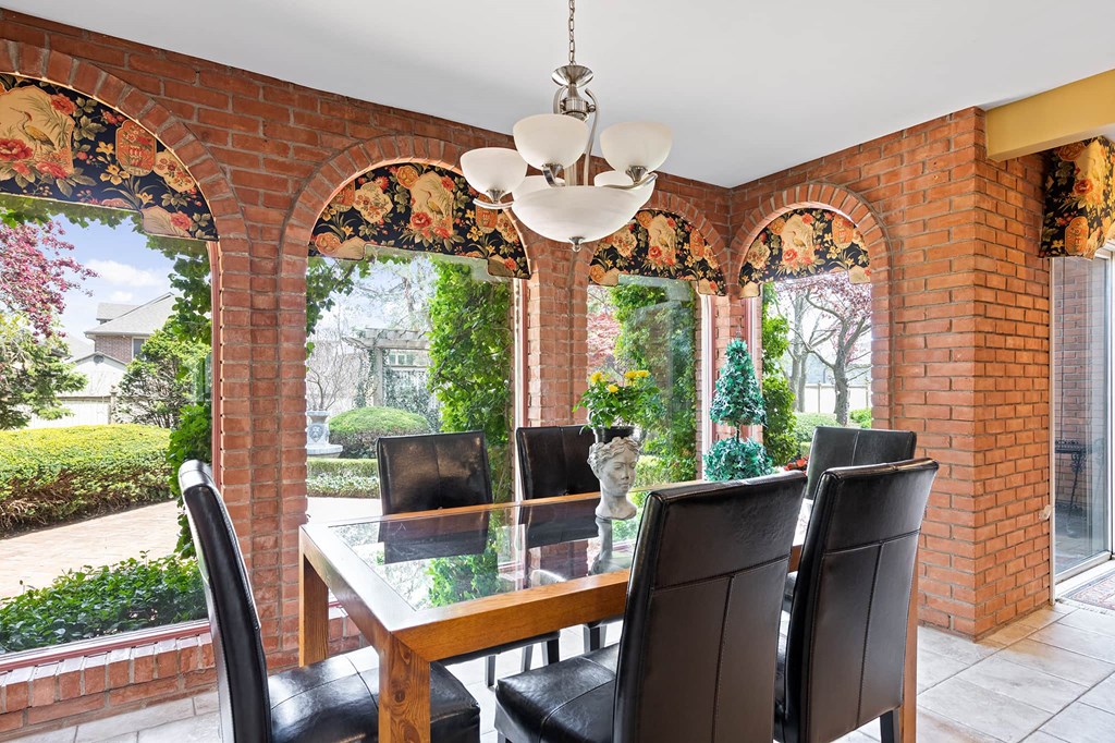 a dining room with a table and chairs in front of arched windows