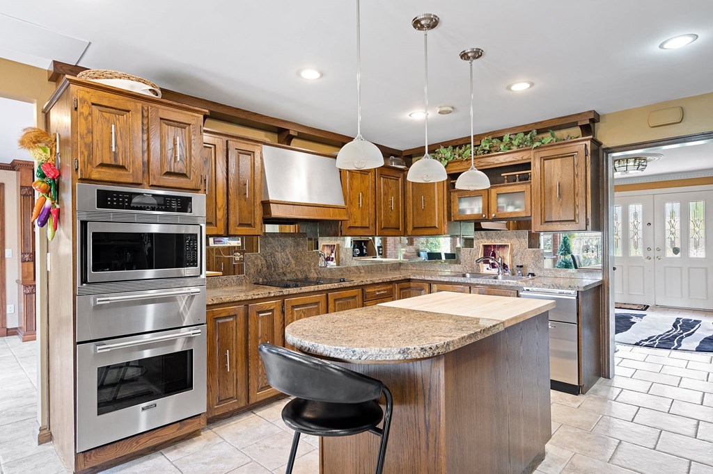 a kitchen with stainless steel appliances and a marble counter top