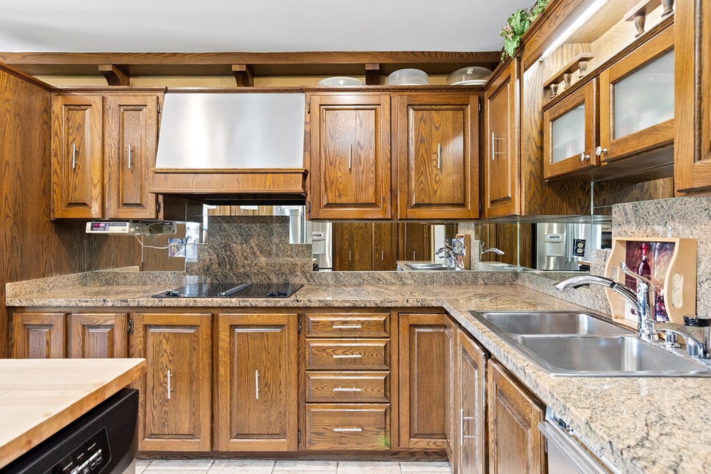 a kitchen with wooden cabinets and granite counter tops