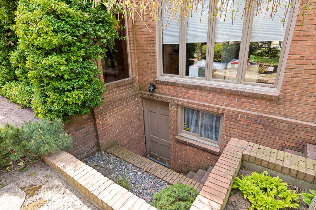 the front of a brick house with a door and a window