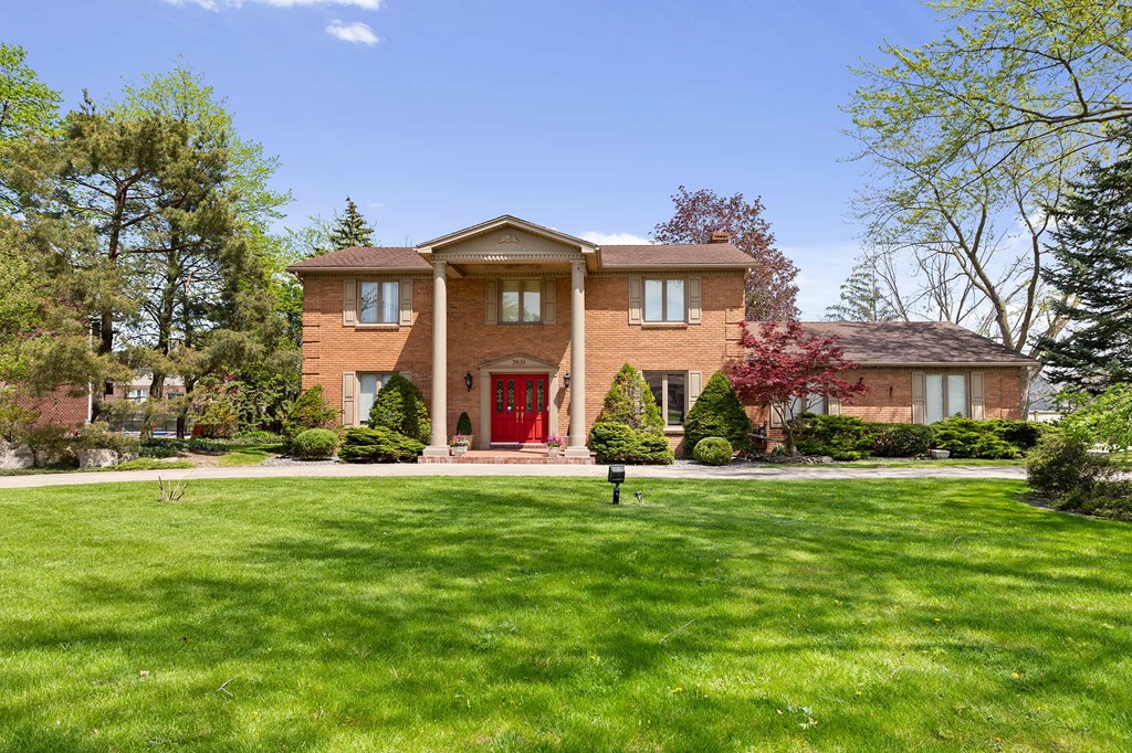a large brick house with a yard in front of it