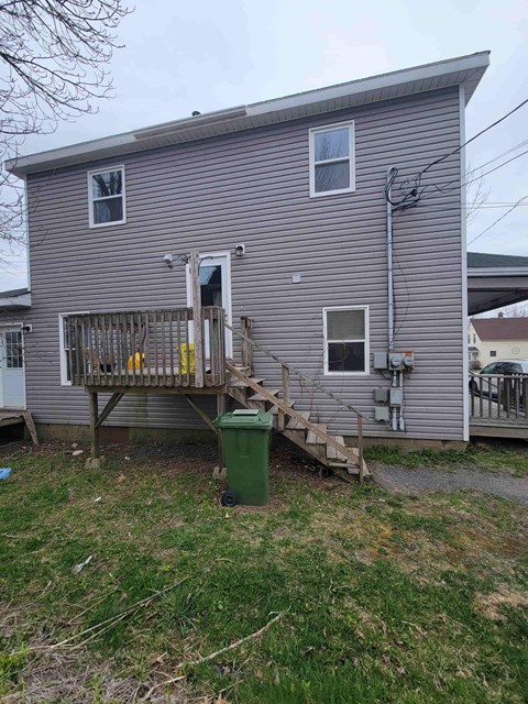 a house with a backdoor and a porch and a green trash can