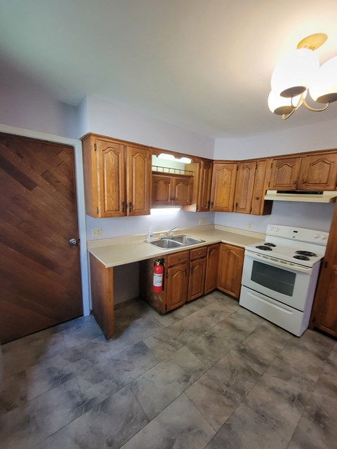 a kitchen with wooden cabinets and a stove and a sink