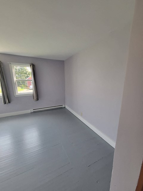 an empty room with white walls and a window