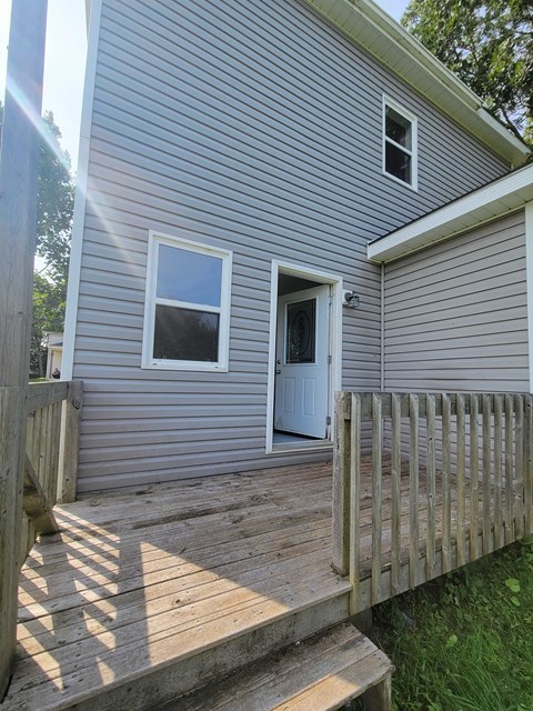 the back deck of a house with a wooden fence